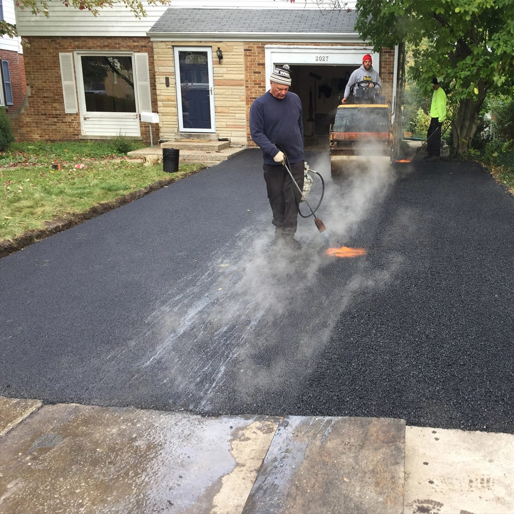 John Zarlengo Asphalt Paving crew using pneumatic roller on residential driveway